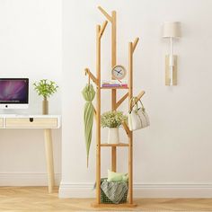 a wooden shelf with potted plants on it in front of a computer desk and wall mounted clock