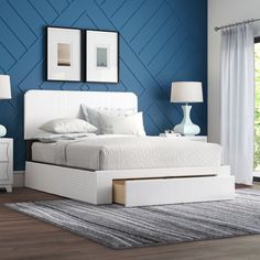 a bedroom with blue walls and white furniture