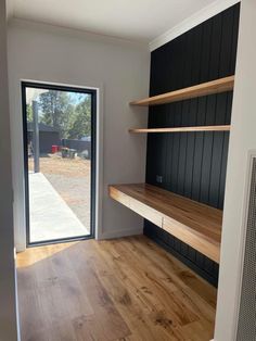 an empty room with wooden shelves and sliding glass doors