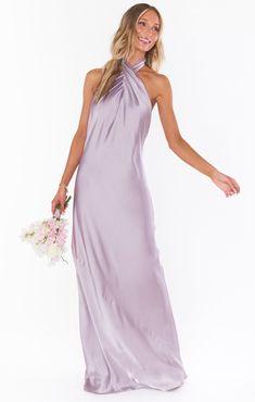 a woman in a long purple dress holding a bouquet