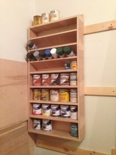 a wooden shelf filled with lots of different types of paint