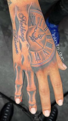 a person's hand with a clock tattoo on it