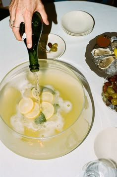 someone is pouring olives into a bowl of water