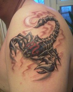 a scorpion tattoo on the back of a man's left shoulder and upper arm