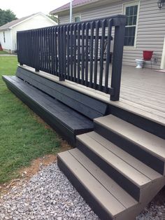 a set of stairs leading up to a house with grass and gravel on the ground