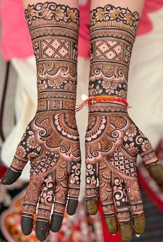 two hands with henna designs on them