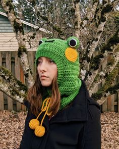 a woman wearing a knitted frog hat and scarf