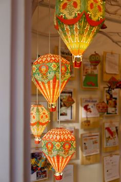 several colorful lanterns hanging from strings in a room