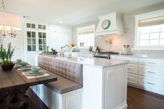 a kitchen with white cabinets and an island in front of the stove top oven is shown