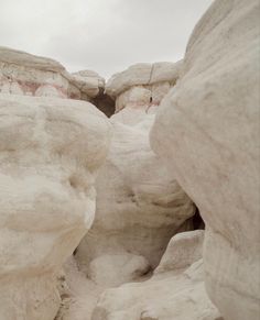 a person standing in the middle of some white rocks and boulders with their feet up