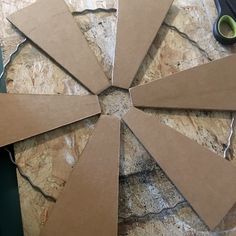 several pieces of cardboard sitting on top of a stone floor next to scissors and tape