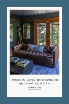 a living room filled with furniture and books on the floor next to a window that reads, embracing the dark side tips for painting your space in bold dramatic colors