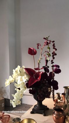 a vase filled with lots of flowers on top of a table next to other items