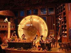 a group of people standing around a large clock in a room with lots of shelves