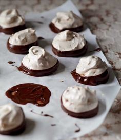 chocolate covered cookies with white frosting on a baking sheet