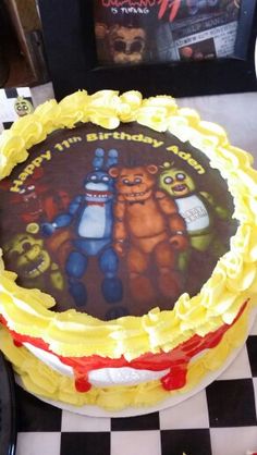 there is a birthday cake with cartoon characters on the frosting and yellow icing