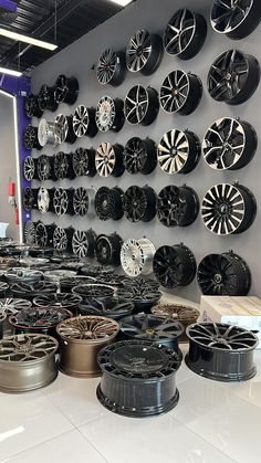 a room filled with lots of different types of wheels and rims on the wall