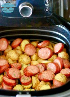 a slow cooker filled with cooked sausage and potatoes