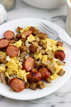 a white plate topped with eggs, sausage and hash browns