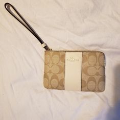 Brand New Coach Brand Wristlet. Length: 6.25" Height: 4.0" Width: 0.5" Color Gold/Lt Khaki/Chalk Signature Costed Canvas And Cross Grain Leather Coach Beige Pouch Wristlet, Beige Coach Pouch Wristlet, Beige Rectangular Coach Clutch, Beige Zipper Closure Wristlet Clutch, Coach Cream Rectangular Wristlet, Coach Beige Wristlet With Removable Pouch, Coach Beige Wallet With Wrist Strap, Coach Beige Wallets With Wrist Strap, Coach Beige Clutch Wristlet