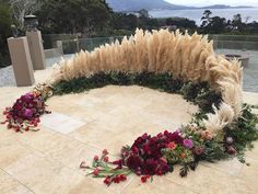 an arrangement of flowers on the ground next to a bench