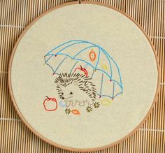 a hedgehog is holding an umbrella in the rain with leaves and apples on it