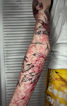 a man's arm with tattoos on it and red ink in the middle of his arm