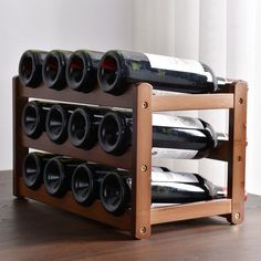 a wooden wine rack with several bottles of wine in it on top of a table