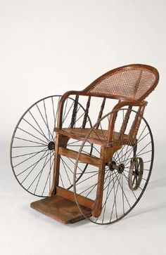 an old fashioned wooden wheel chair on wheels