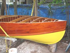 a small wooden boat is sitting on the ground