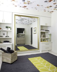 a large mirror sitting in the middle of a living room next to a yellow rug