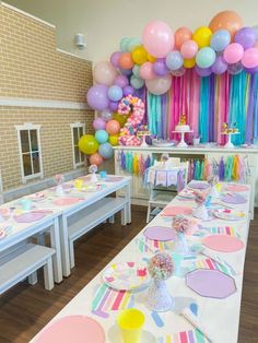 a table set up for a birthday party with balloons and streamers