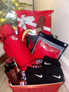 a basket filled with sports items next to a christmas tree