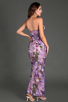 a woman wearing a purple floral print dress with high slits on the side and back