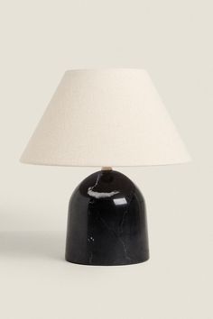 a black table lamp with a white shade