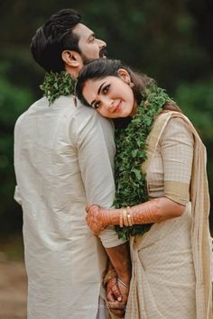 a man and woman standing next to each other with their arms around each other, smiling