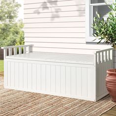 a potted plant sitting next to a white bench