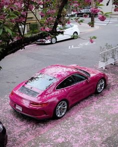 a pink car is parked on the side of the road with flowers all over it