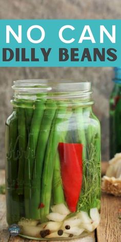 mason jar filled with pickled green beans and red bell peppers on top of a wooden table