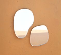 there are two mirrors on the wall that have been made to look like an oval shape