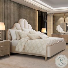 a large white bed sitting inside of a bedroom next to a night stand and two lamps