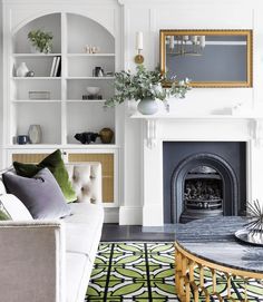 a living room filled with furniture and a fire place in front of a white fireplace