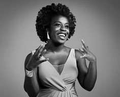 a black and white photo of a woman with her hands in the air, smiling