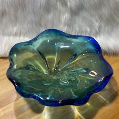 a blue glass bowl sitting on top of a wooden table