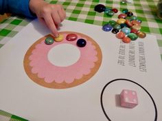 a child's hand pointing at a piece of paper with candy on it