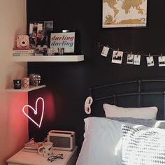 a bed room with a neatly made bed next to a night stand and pictures on the wall