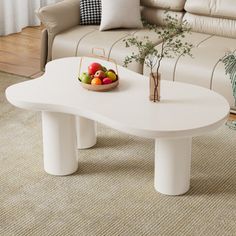 a white coffee table with fruit on it