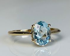 Lovely vintage genuine Aquamarine engagement ring with stunning natural earth mined Aquamarine in 14k gold. The Aquamarine is a beautiful tropical water blue with aqua green hue and is estimated to weigh 1.75 carats (~9 mm x 7 mm). The stone is an older oval cut with a smaller high table and appears to be unheated (rare!). Inside of the ring is stamped for 14k gold. Details: Ring is stamped for 14K.  Ring weighs 2.8 grams.  Currently a size 6.5 and can be sized by adding our custom sizing listin Cushion Cut Aquamarine Engagement Ring, Aquamarine And Gold Ring, Gold Aquamarine Engagement Ring, Oval Aquamarine Birthstone Ring Fine Jewelry, Oval Aquamarine Birthstone Ring, Aquamarine Oval Ring, Classic Aquamarine Birthstone Ring, Blue Solitaire Emerald Ring In Classic Style, Blue Solitaire Emerald Ring Classic Style