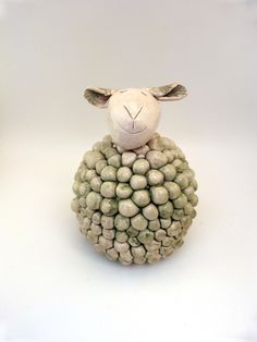 a sheep made out of grapes on a white surface