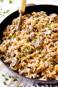 a skillet filled with pasta and meat